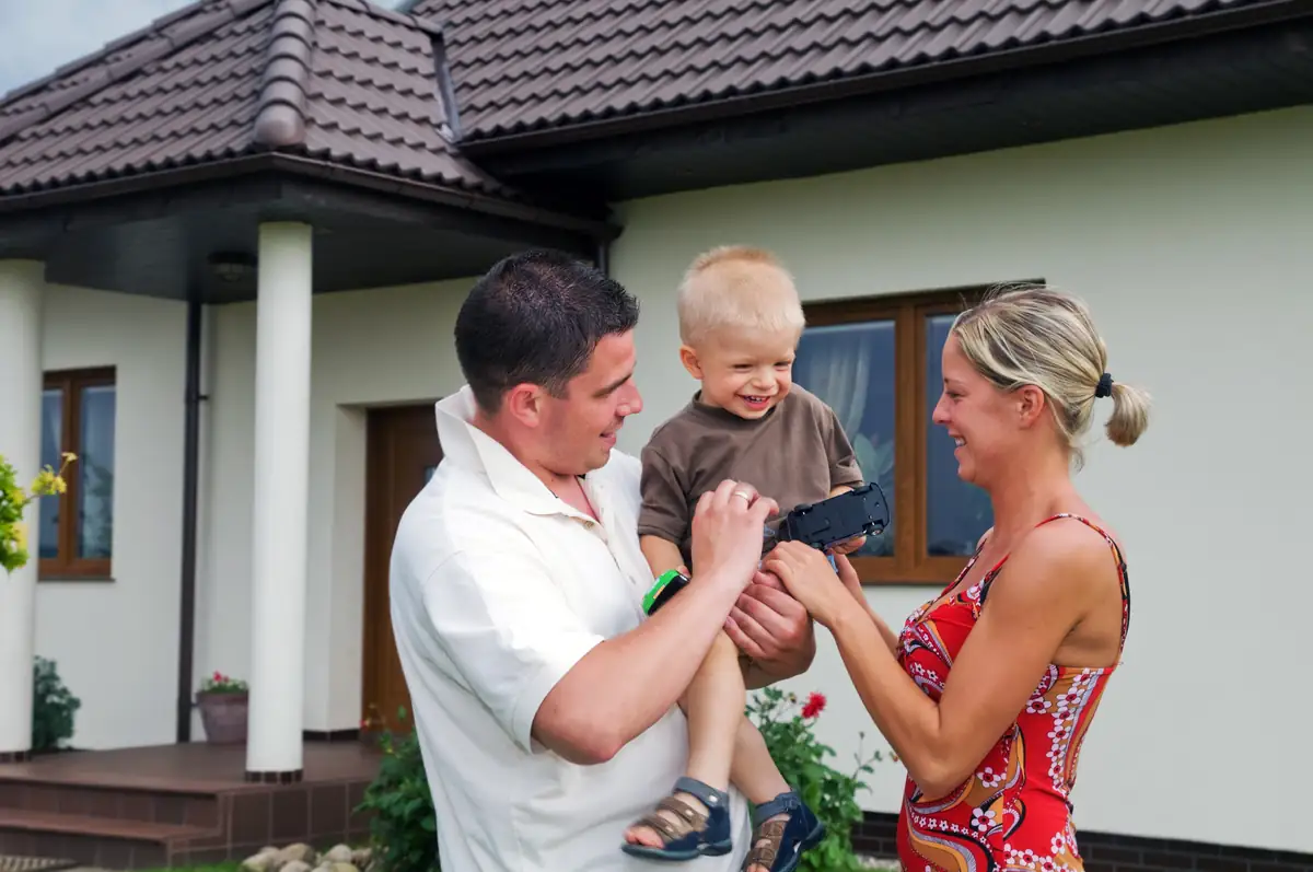 Family standing outside their California manufactured home after a completed title transfer
